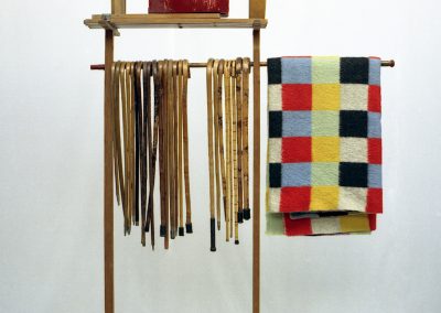 Compositie met wandelstokken, klapstoeltjes en een deken